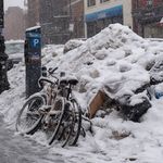 A person walks by a big pile of snow and garbage in Greenpoint.